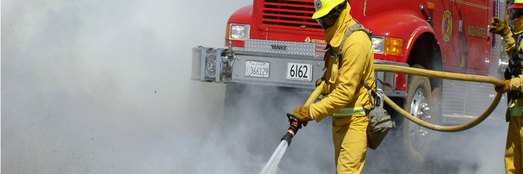 Fireman in front of firetruck with hose
